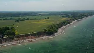 High aerial view of peaceful coastline scenery, Baltic sea shoreline in Brodten, Germany, dolly in