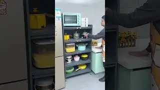 Kitchen rack with cabinet doors, floor-standing multi-layer storage cabinet, microwave oven, pots.