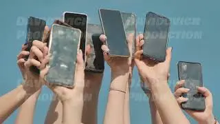 Many hands holding up smartphones with cracked and broken screens against a clear blue sky.