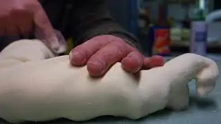 Sanding and sculpting a polyurethane foam arm.