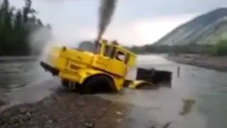 A Russian tractor driver refuses to give up after his vehicle gets stuck in a river.