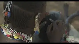 Larim tribe woman making braids to a friend, Boya Mountains, Imatong, South Sudan