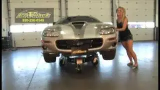 Girl moves car with rolling jack stand