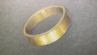 Anello d’oro con le matite colorate su cartoncino scuro