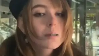 A French woman smokes a cigarette at the table and throws the butt on the floor and spits.