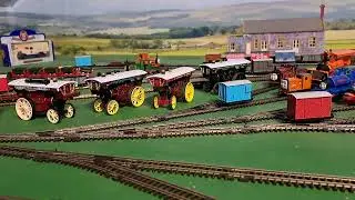 Bachmann Rheneas pulling 1 brown, 1 red, 1 grey slate wagons and blue box van 