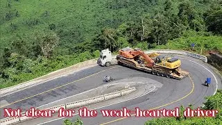 Overloaded tractor-trailer carrying two large excavators climbs the dramatic pass