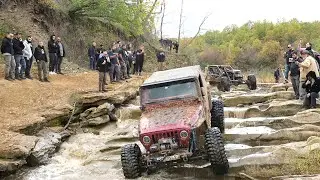 Jeep in river slippery rocks