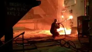 Сталевар кислородом подрезает горловину конвертера