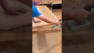 Planing a wide wooden board smoothly using electric hand planer for flat even surface finish work