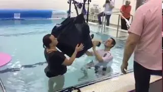 Hydrotherapy demonstration - Pool rescue manikin lifted from pool using a hoist