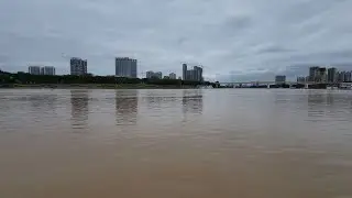 Nanning: river has risen in a rare cool day of summer中国南宁2022年5月15日：邕江涨水，堤岸边的一些草已浸入水中。 5月中旬气温之低同期罕见