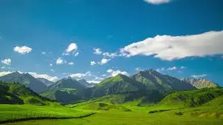 Serene landscape of rolling green hills and mountains in rural Kyrgyzstan - time lapse