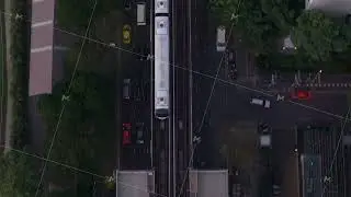 Birds eye perspective of a modern elevated train leaving a station in Bangkok, Thailand. Busy city