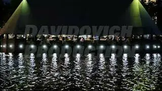Floating restaurant on Moscow river at night with people dining, water reflections