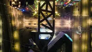 Top down ascending footage of traffic on roads in night city. Hyperlapse shot of illuminated streets