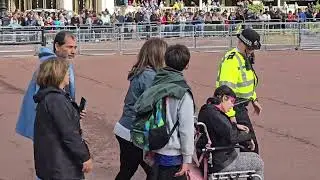 Police help disabled girl across the road to watch changing of the guard look how happy she is.