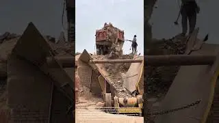 Unloading Rocks into Crusher: Manual Labor and Heavy Machinery