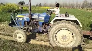 little child driving tractor on field