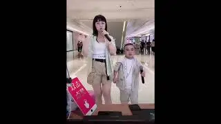 Asian tall woman with short man, they are singing song.