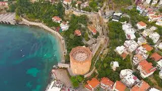 Alanya, Turkey. Top-down vertical drone shot of Kizilkule Red Tower roof and surrounding pathways...