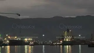 The bustling shipping port and hub of transportation at night filmed in timelapse