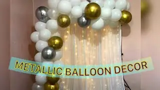 Metallic balloon backdrop with curtain lights