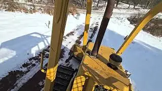 Plowing snow banks with the John Deere 450G Dozer.