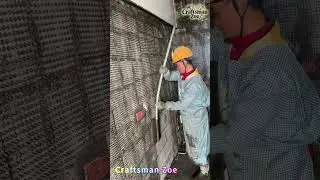 Workers use nets to hang concrete mortar on the walls of indoor buildings