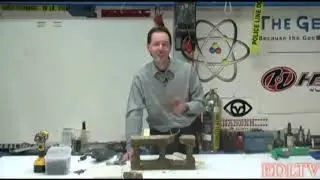 Chris Boden attempts to drill holes into a disintegrating cinderblock for ExpertVillage