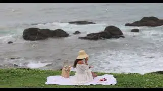 Picnic of Boho Woman in Vintage White Dress at the Beach