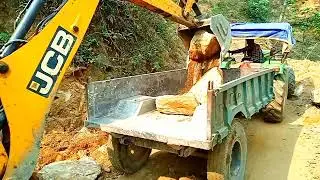 JCB backhoe loading big stone into a Tractor John Deere 5310, Mahindra Arjun Novo mountain king