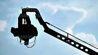 Silhouette of tv camera on crane recording video against blue sky in Vietnam