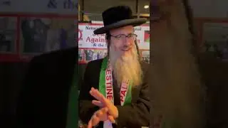Rabbi Dovid Feldman at the Neturei Karta booth at the AMP convention