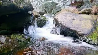 water fall among frozen rocks, mountain river in winter - zoom out