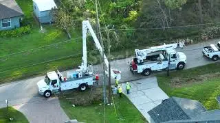 Aerial view of electrician workers repairing damaged power lines after hurricane Ean