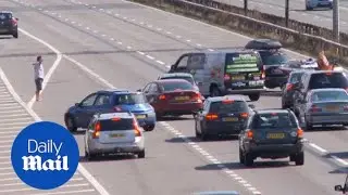 Dramatic moment BAREFOOT man halts four lanes of traffic - Daily Mail