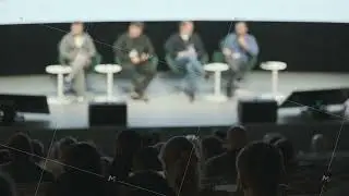 Panel discussion on stage with four speakers and an attentive au
