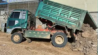 Pour the soil and let the abul push it Dump Truck of Bulldozer Fill the lake with soil