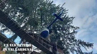 Un elicottero MBB BO105 a Ortisei tra i rami degli alberi