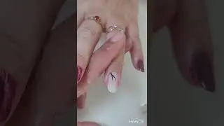 Decoração feita com pincel e tinta de tecido fazendo um raminho nas unhas 