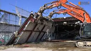 Demolition excavators working in tandem to demolish industrial unit.