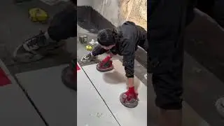 installing large white ceramic floor tiles carefully