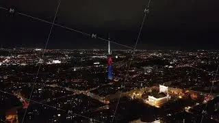 Zizkov Television Tower glowing over the Prague skyline at night, highlighting the National Monument