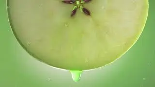 Flowing Green Apple Juice from Apple slice , macro shot in slow motion