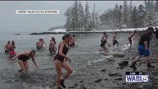 Dozens brave the cold by going for a dip in a Tremont beach