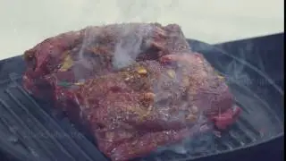 Turning pieces of beef meat - close-up on top of a kitchen tile