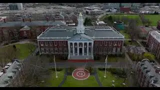Aerial descending shot of Baker Library building. Beautiful brick building with white tower. Boston