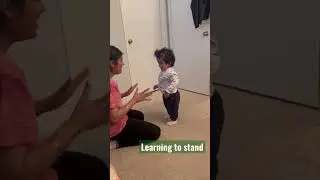 Baby standing on his own 1 year old