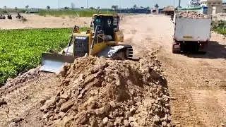 一条新铺设的土石方道路正在横穿水域，推土机和卡车相互配合！ #作品同步头条赢激励 #推土机 #土石方工程 #卡车 #解压